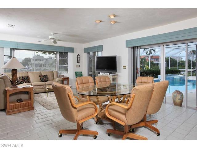 306 Devils Bight Naples, FL 34103 - Photo 3 of 17 a living room with patio furniture and a flat screen tv