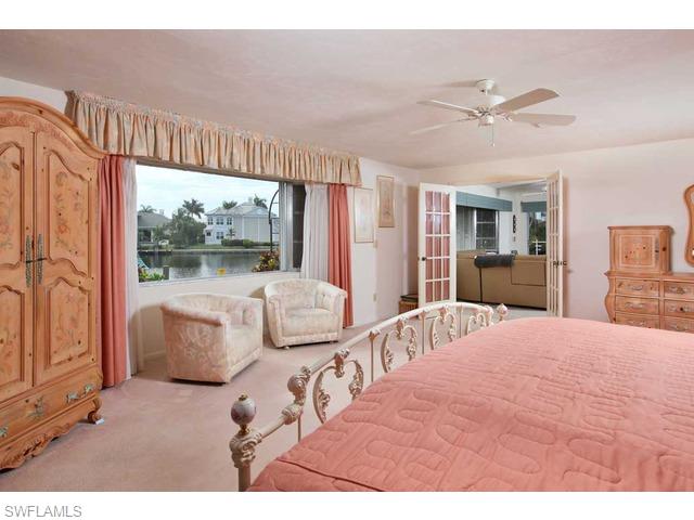 306 Devils Bight Naples, FL 34103 - Photo 7 of 17 a bedroom with a large bed and a large window