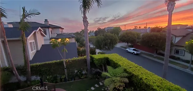 a view of a house with a yard and potted plants