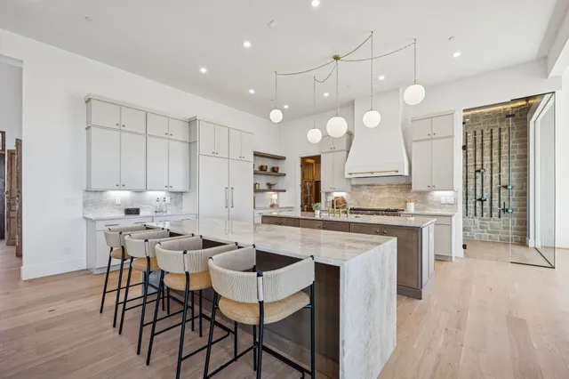 a view of a kitchen from the hallway with closet and wooden floor