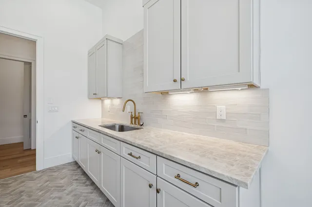 a bathroom with a granite countertop bathtub shower sink vanity and toilet