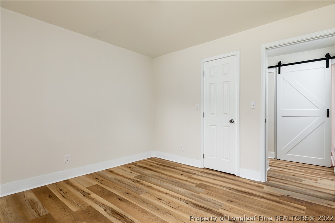 344 J Burns Road Vass, NC 28394 - Photo 22 of 50 a view of a room with wooden floor and a white door
