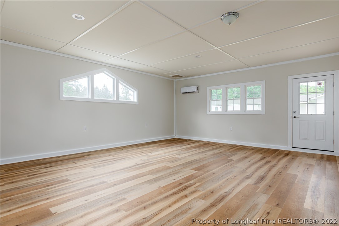 344 J Burns Road Vass, NC 28394 - Photo 24 of 50 an empty room with wooden floor and windows