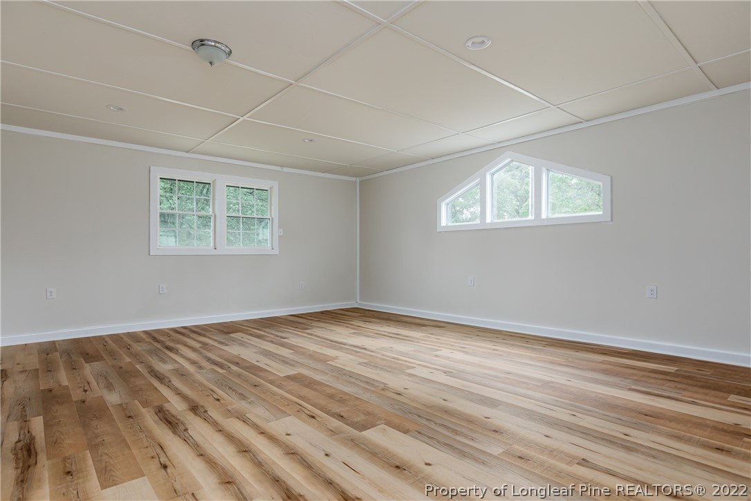 344 J Burns Road Vass, NC 28394 - Photo 26 of 50 an empty room with wooden floor and windows