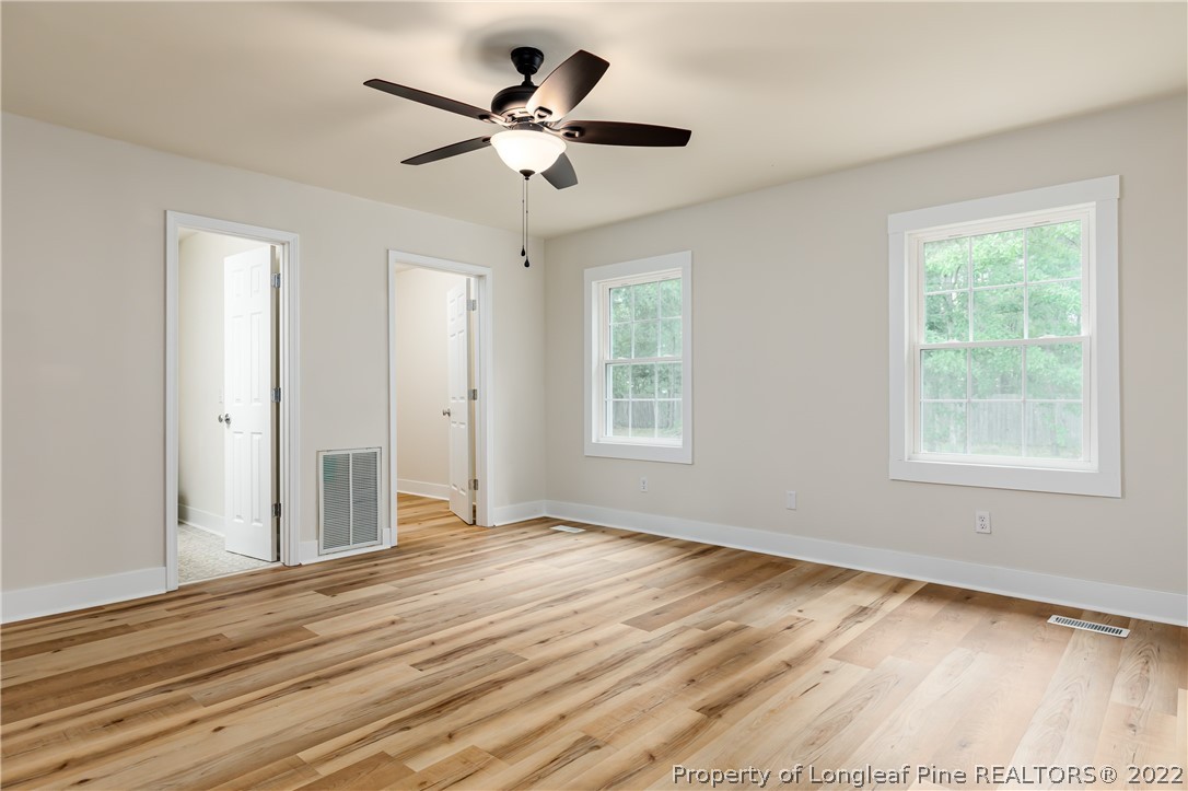 344 J Burns Road Vass, NC 28394 - Photo 10 of 50 an empty room with wooden floor and windows