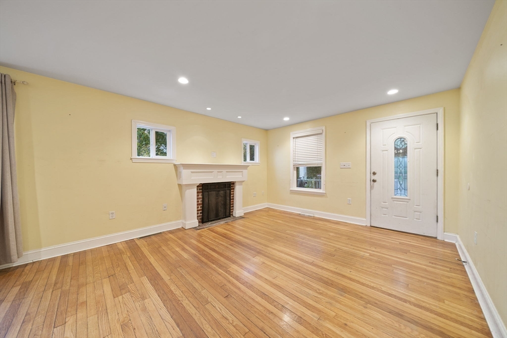 53 Mountford Road Hull, MA 02045 - Photo 6 of 35 a view of empty room with wooden floor and fireplace