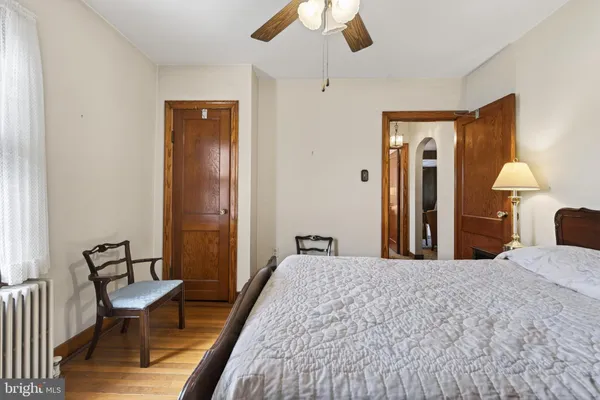 a bedroom with a bed chandelier and a window