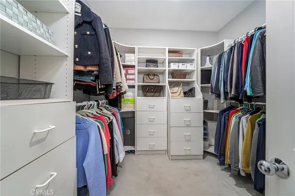 a view of walk in closet with clothes and shoes