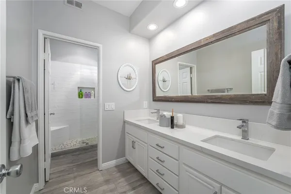 a bathroom with a double vanity sink mirror and shower