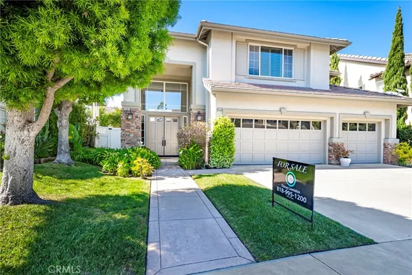a front view of a house with a yard and potted plants