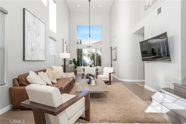 a living room with furniture a flat screen tv and kitchen view