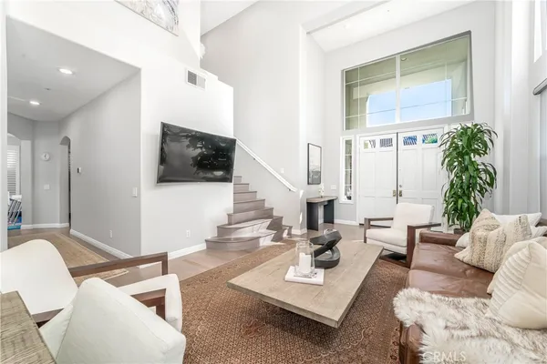 a living room with furniture a flat screen tv and a large window