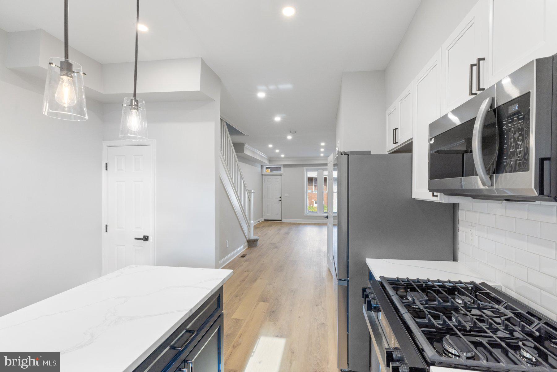 653 Bartlett Avenue Baltimore, MD 21218 - Photo 11 of 39 a kitchen with stainless steel appliances a refrigerator and a stove top oven