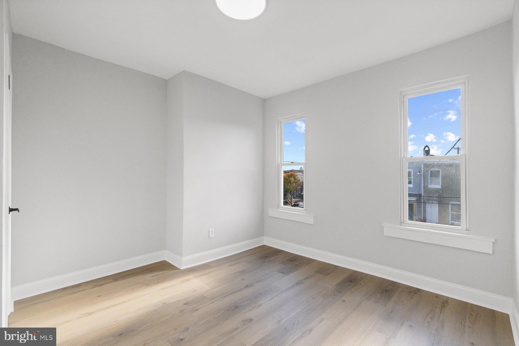 653 Bartlett Avenue Baltimore, MD 21218 - Photo 16 of 39 a view of an empty room with a window and wooden floor