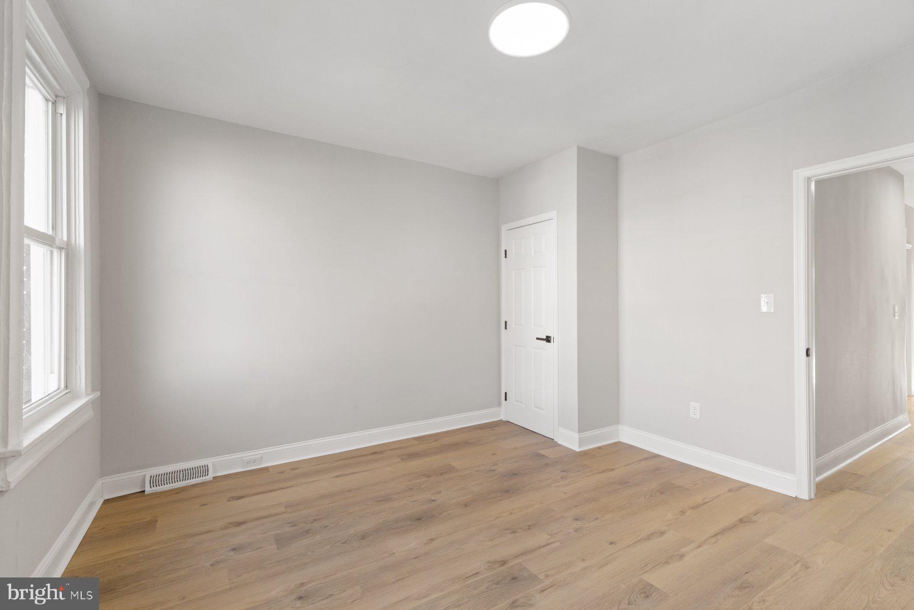 653 Bartlett Avenue Baltimore, MD 21218 - Photo 17 of 39 an empty room with wooden floor and windows