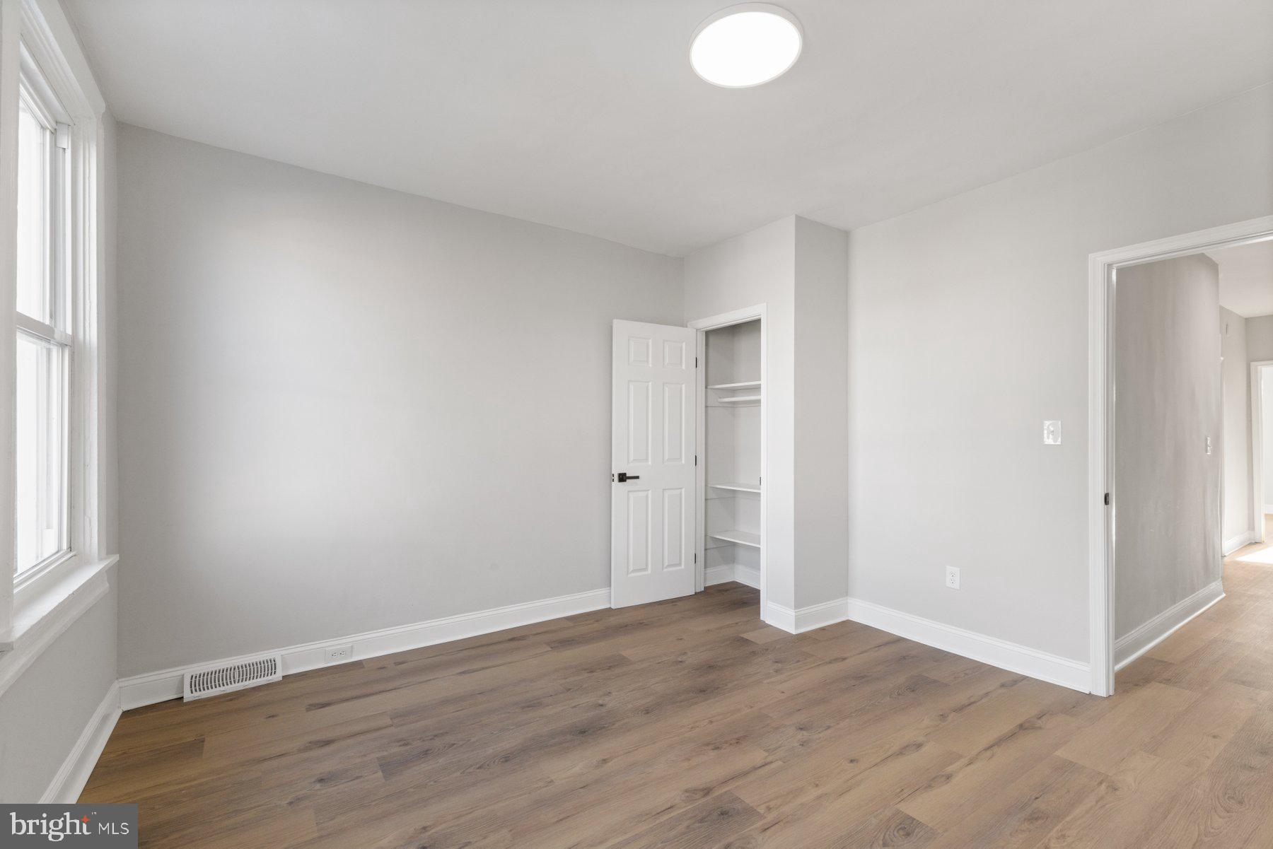 653 Bartlett Avenue Baltimore, MD 21218 - Photo 19 of 39 an empty room with wooden floor and windows