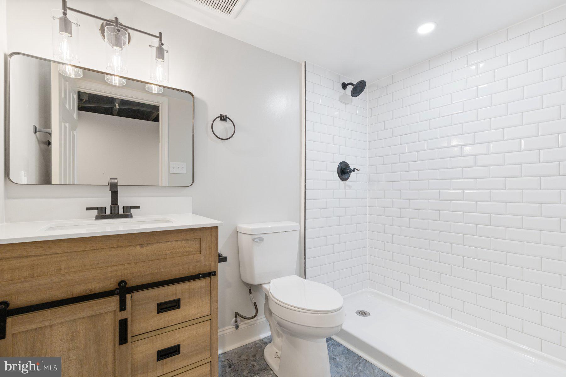 653 Bartlett Avenue Baltimore, MD 21218 - Photo 32 of 39 a bathroom with a sink a toilet a mirror and shower