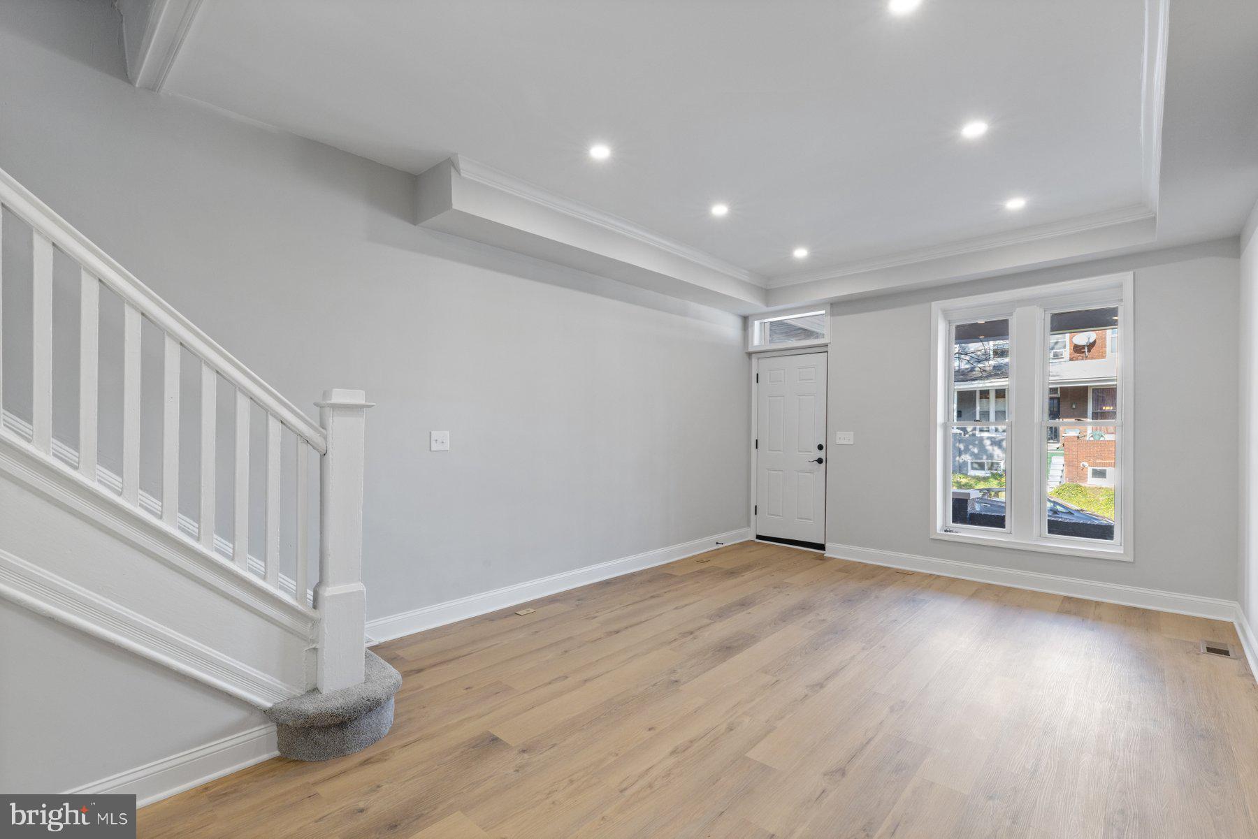 653 Bartlett Avenue Baltimore, MD 21218 - Photo 5 of 39 a view of an empty room with wooden floor and entryway