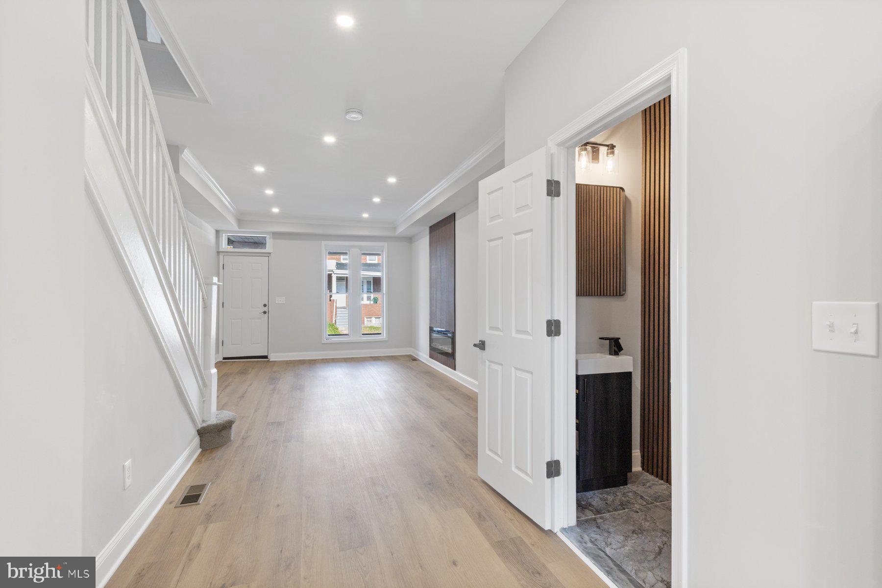 653 Bartlett Avenue Baltimore, MD 21218 - Photo 6 of 39 a view of a hallway with wooden floor and staircase