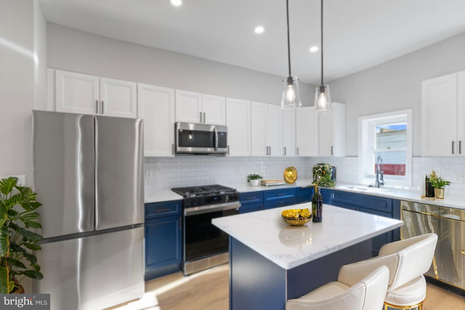 653 Bartlett Avenue Baltimore, MD 21218 - Photo 8 of 39 a kitchen with stainless steel appliances a stove a refrigerator a sink a table and chairs