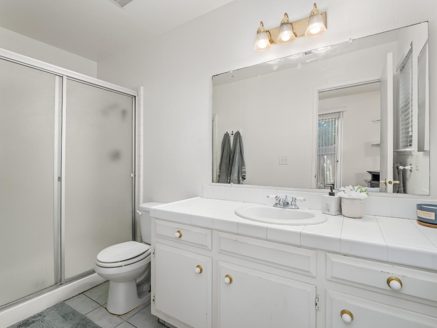 468 Burgan Avenue Clovis, CA 93611 - Photo 17 of 24 a bathroom with a sink a toilet and a mirror