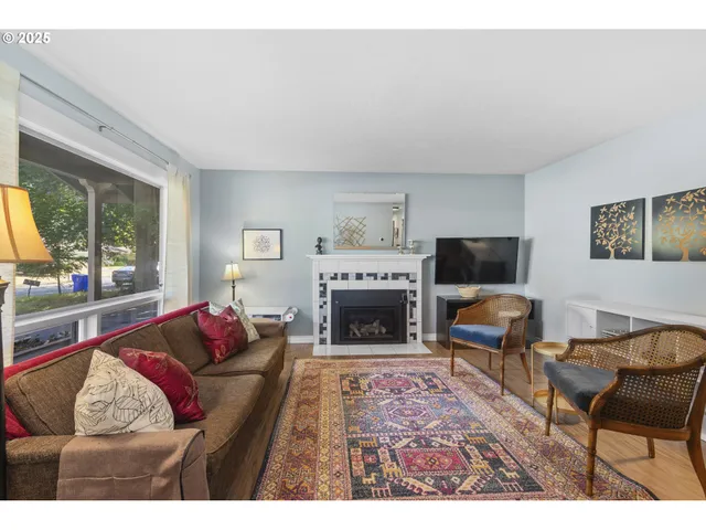 a living room with furniture a flat screen tv and a fireplace