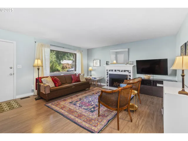 a living room with furniture a flat screen tv and a fireplace