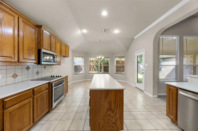 a large kitchen with stainless steel appliances granite countertop a sink and a refrigerator