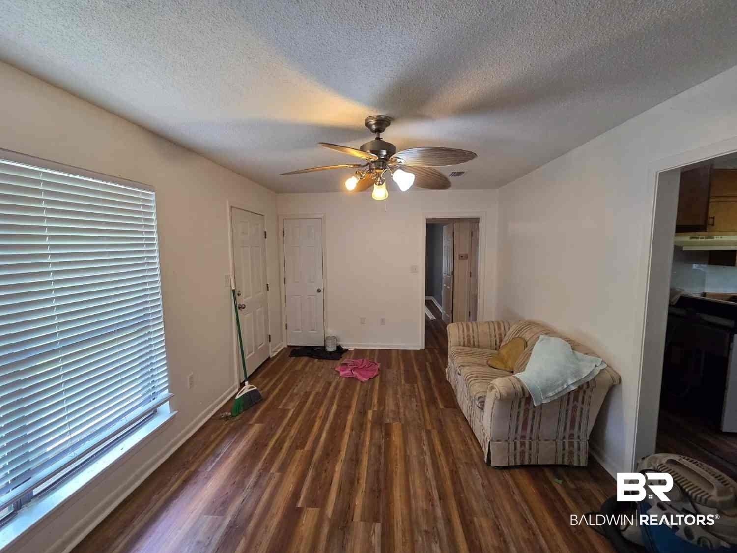 106 West 16th Street Bay Minette, AL 36507 - Photo 11 of 19 Living area featuring wood finished floors, a ceiling fan, a textured ceiling, baseboards, and healthy amount of natural light