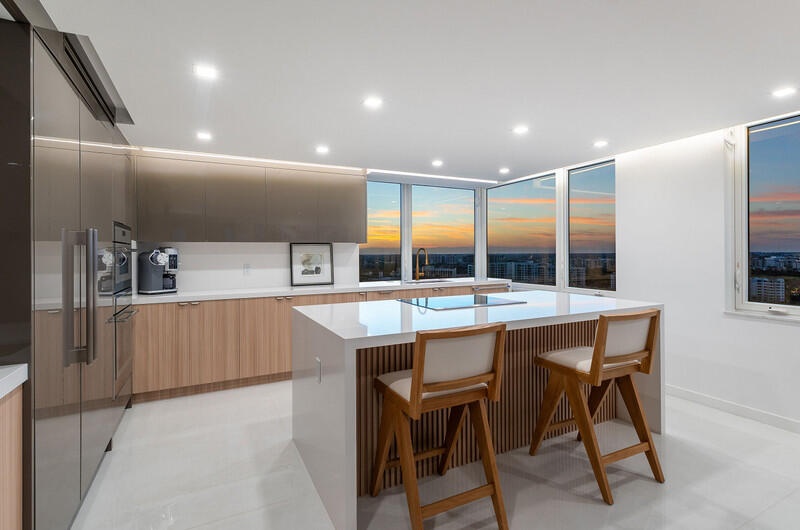 550 South Ocean Boulevard, Unit 2207 Boca Raton, FL 33432 - Photo 13 of 42 a kitchen with stainless steel appliances kitchen island granite countertop a table chairs sink and cabinets