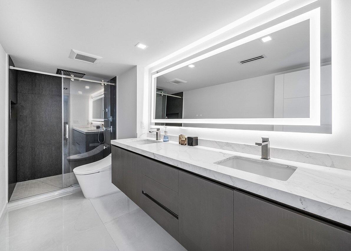 550 South Ocean Boulevard, Unit 2207 Boca Raton, FL 33432 - Photo 21 of 42 a bathroom with a double vanity sink a mirror and a shower