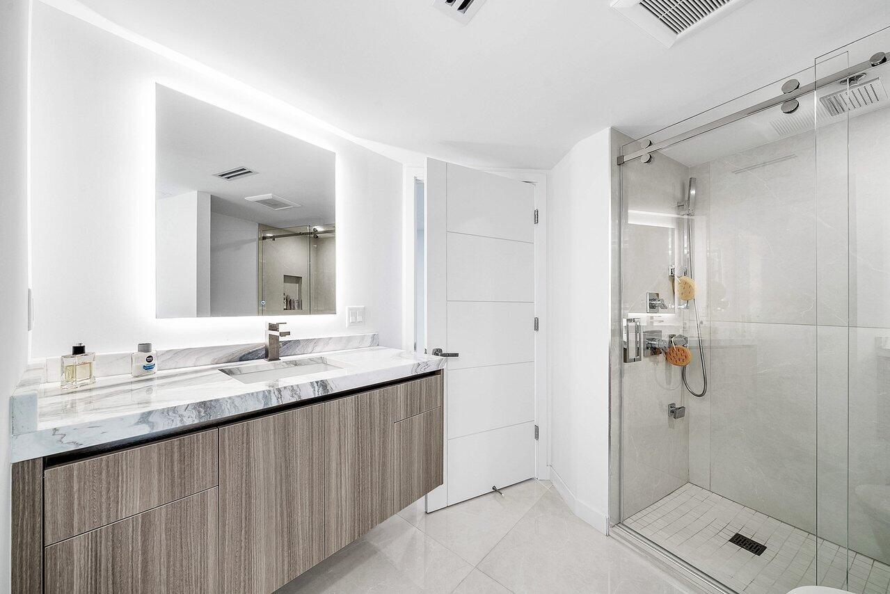 550 South Ocean Boulevard, Unit 2207 Boca Raton, FL 33432 - Photo 24 of 42 a bathroom with a granite countertop sink two mirror and shower