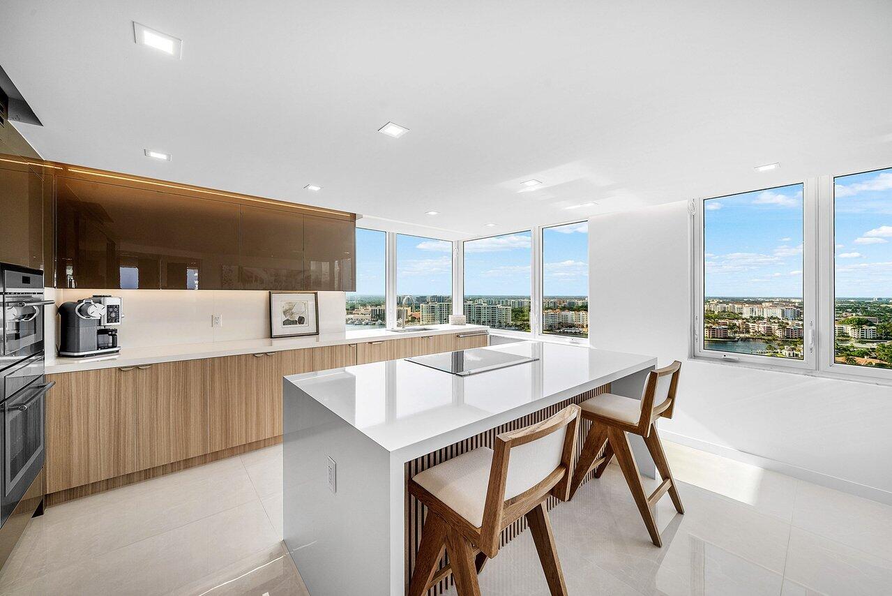 550 South Ocean Boulevard, Unit 2207 Boca Raton, FL 33432 - Photo 6 of 42 a kitchen with stainless steel appliances a table and chairs in it