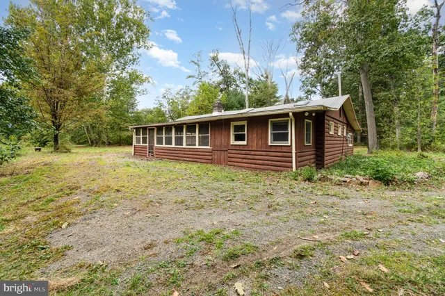 a view of a house with a yard and a large tree