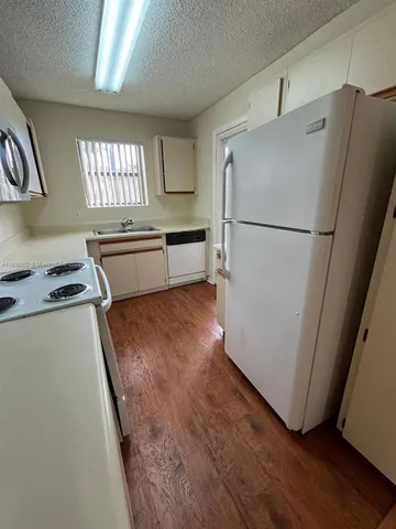 a kitchen with stainless steel appliances a refrigerator a sink and a stove