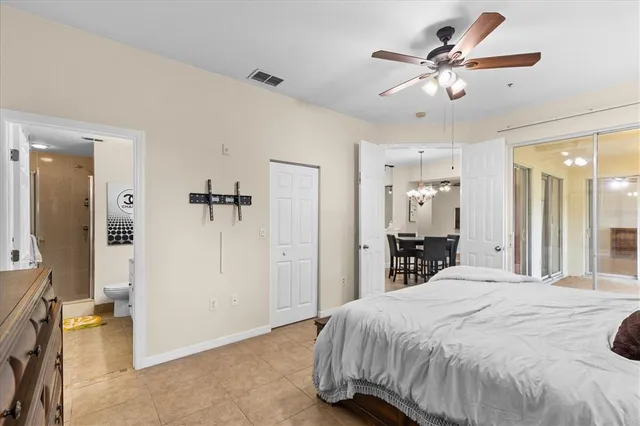 a spacious bedroom with a bed and a chandelier