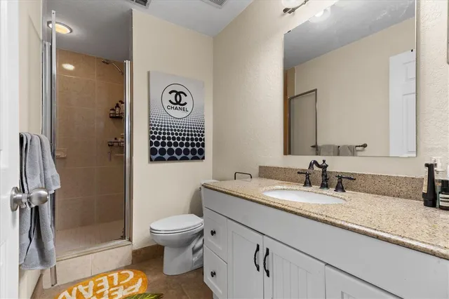 a bathroom with a granite countertop toilet sink and a mirror