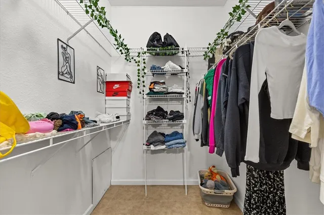 a view of walk in closet with clothes and shoes