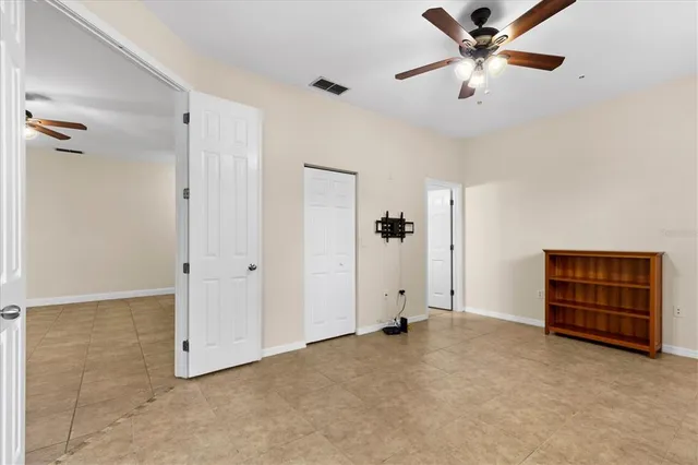 an empty room with closet and fan
