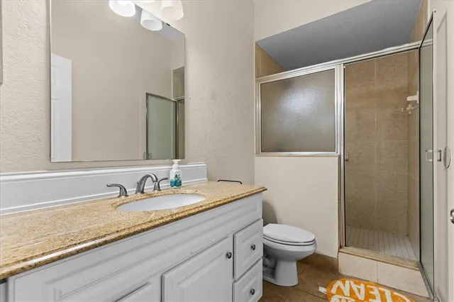 a bathroom with a granite countertop sink toilet and shower