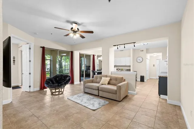 a living room with furniture ceiling fan and a large window