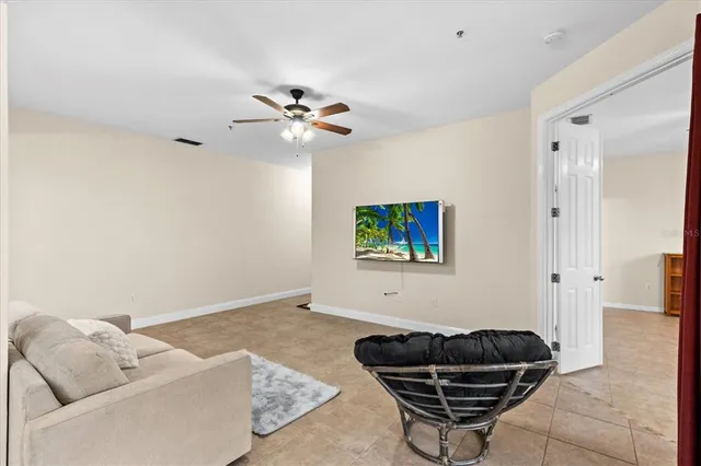 a living room with furniture and a ceiling fan