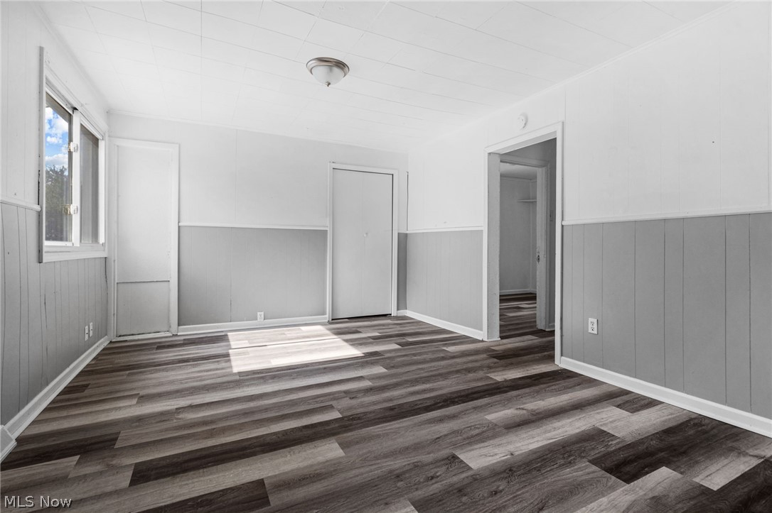 2387 29th Street Southwest Akron, OH 44314 - Photo 4 of 24 Spare room with dark wood-style flooring and wainscoting