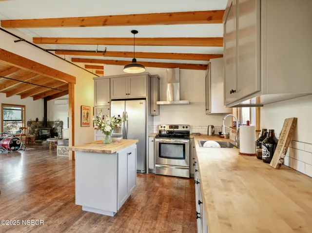 a kitchen with refrigerator and stove top oven