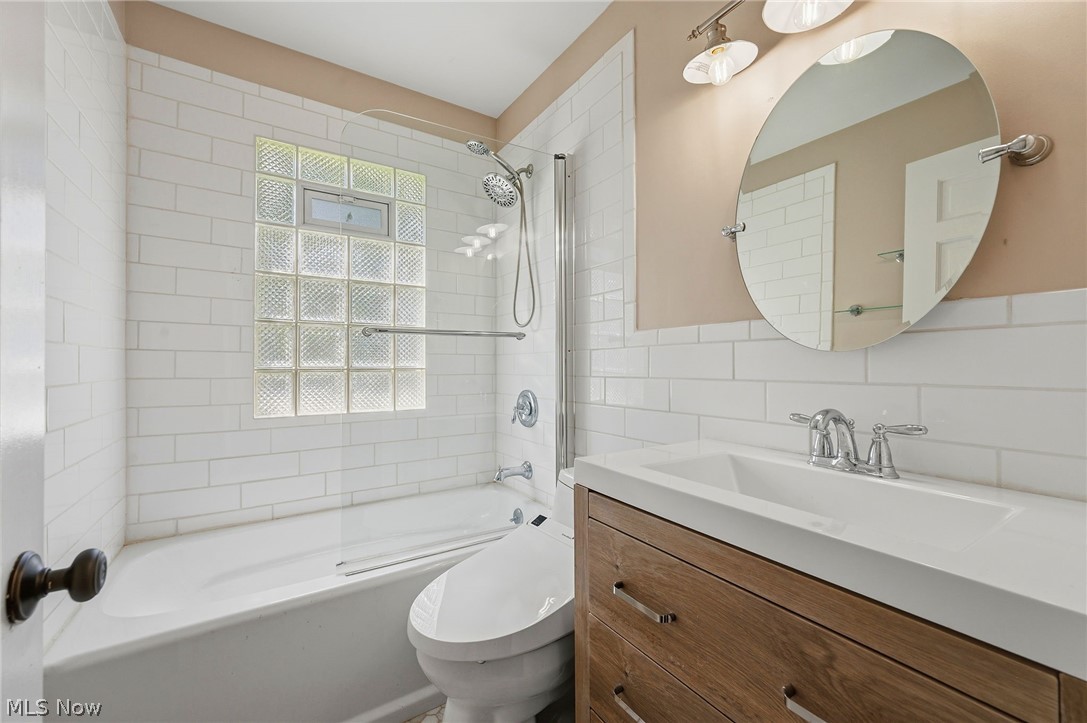7750 Lewis Road Olmsted Falls, OH 44138 - Photo 24 of 50 Bathroom featuring a built-in tub and shower combination with white subway tile surround and a glass block window
