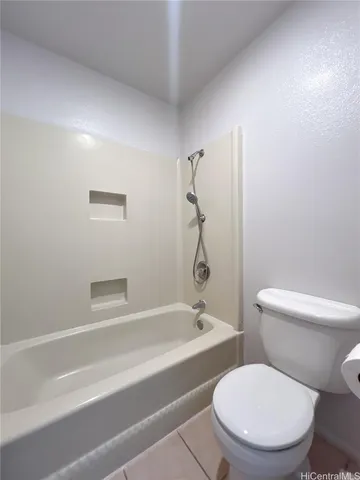 a white toilet and tub sitting next to a bathroom sink