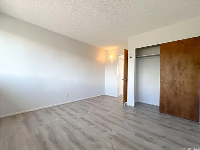 an empty room with wooden floor and closet