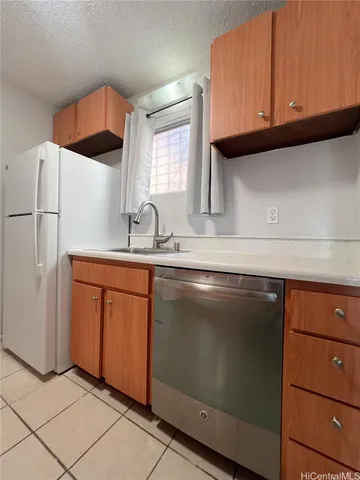 a kitchen with stainless steel appliances granite countertop a sink and a refrigerator