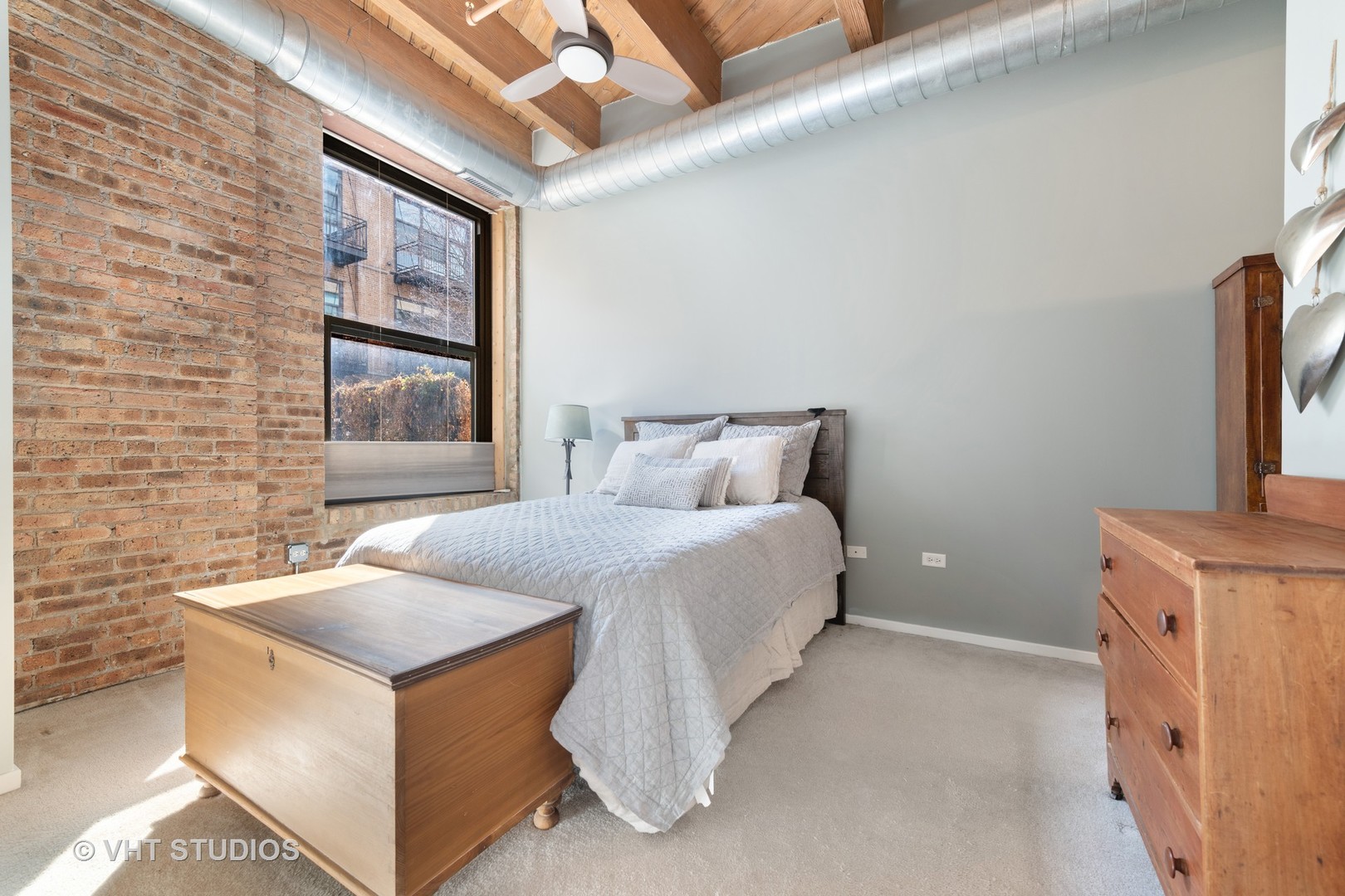 1040 West Adams Street, Unit 248 Chicago, IL 60607 - Photo 12 of 19 a bedroom with a bed and a dresser next to a window