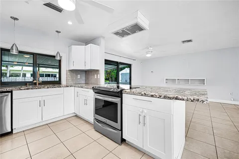 a kitchen with granite countertop cabinets a sink and appliances